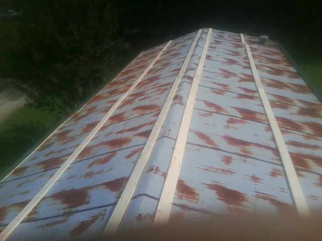 Rusted metal roof panels with new wood purlins before replacement — Storm Damage Roof Repair in East New Market by Roofing Brothers