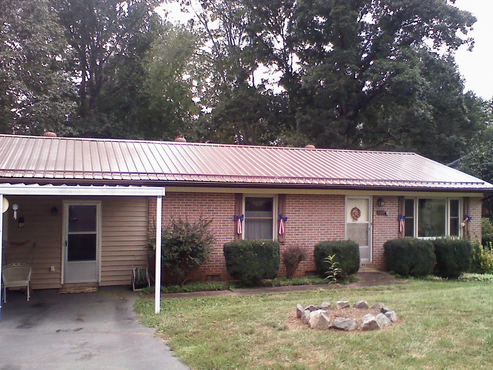 Bronze metal roof and carport on a brick ranch home — Roof Repair work by our crew in East New Market